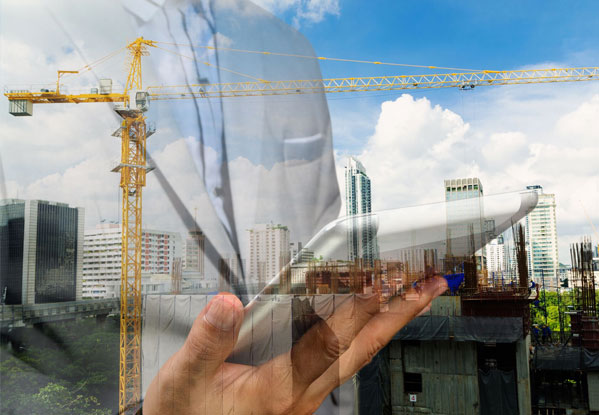 Overlay of a user holding a tablet in a construction area with a crane at a distance